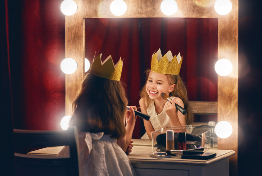 young girl applying stage makeup