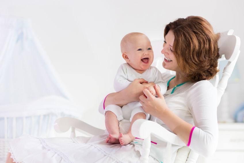 new mom, young, mother, holding newborn child, mom nursing, baby, woman, new born, boy, white bedroom, rocking chair, blue crib, nursery interior, mother playing, laughing kid, family at home